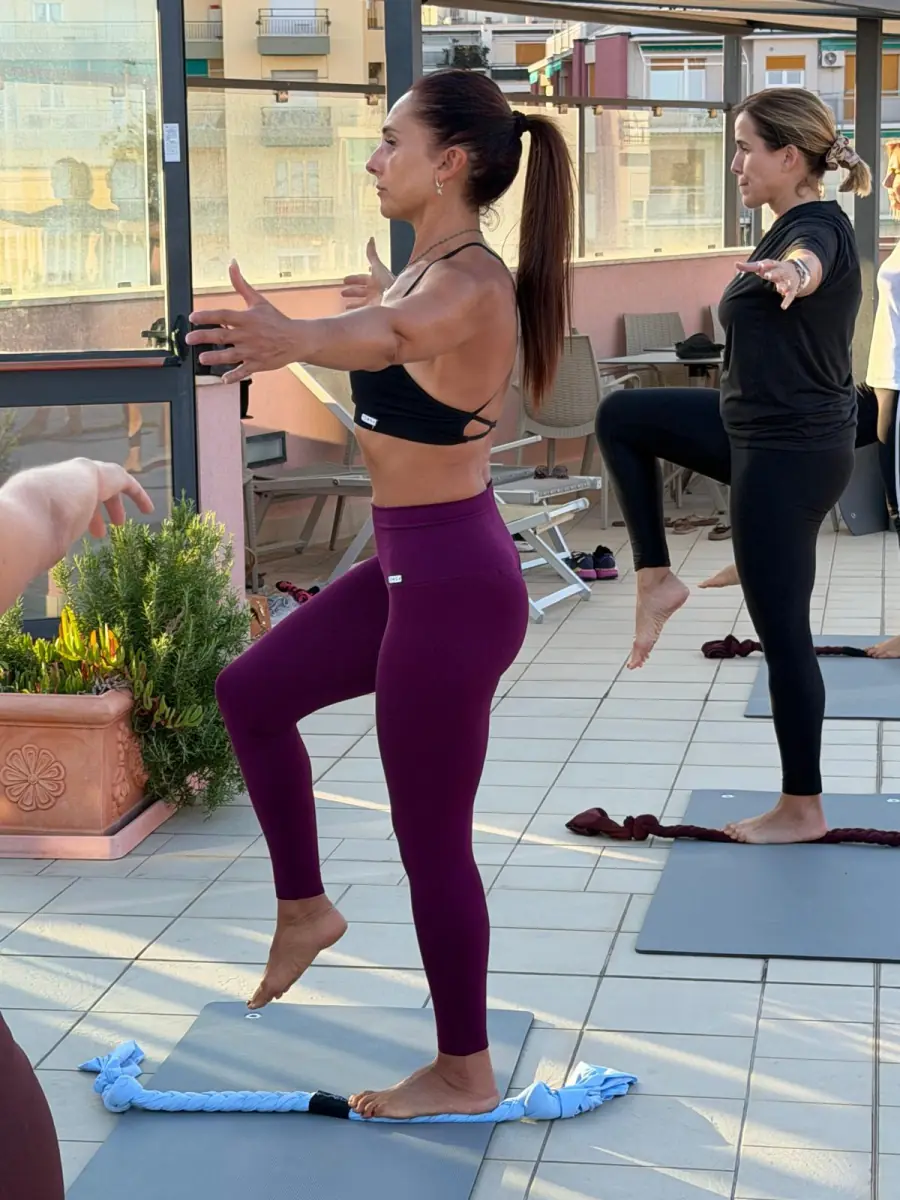 Esercizio di equilibrio su una gamba durante una lezione in gruppo all'aperto